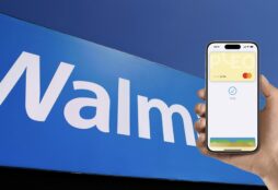 IMAGE: A hand using Apple Pay on top of the Walmart logo.